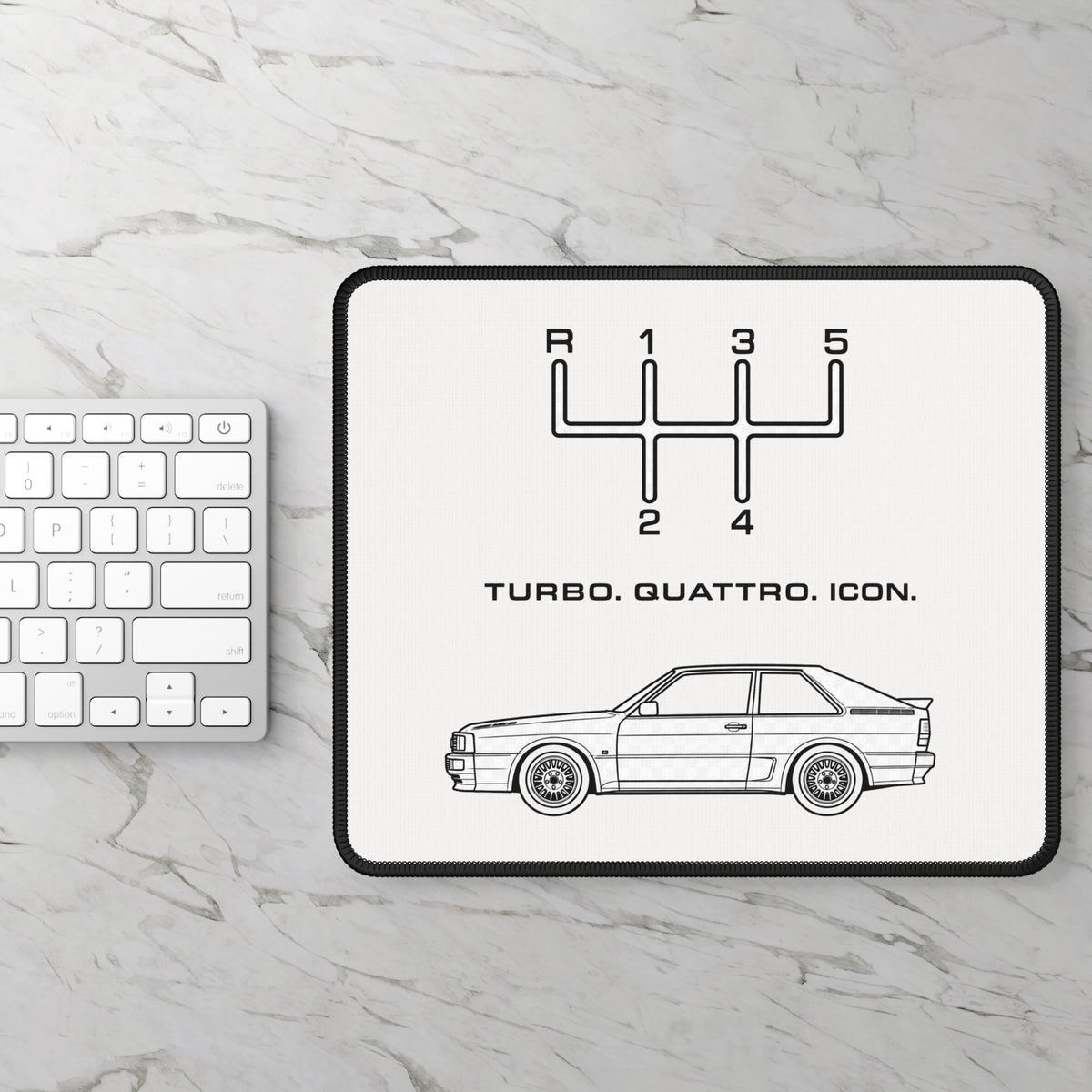 Turbo Quattro Icon mouse pad photographed on a light stone desk alongside a white keyboard