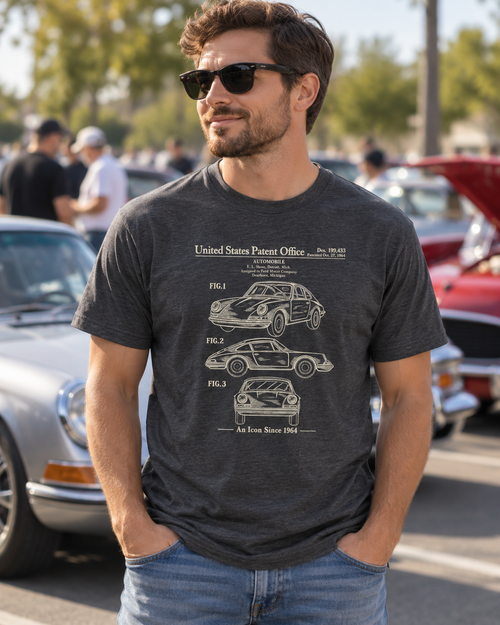 Man wearing the dark heather grey 1964 automobile patent T-shirt at an outdoor classic car meet