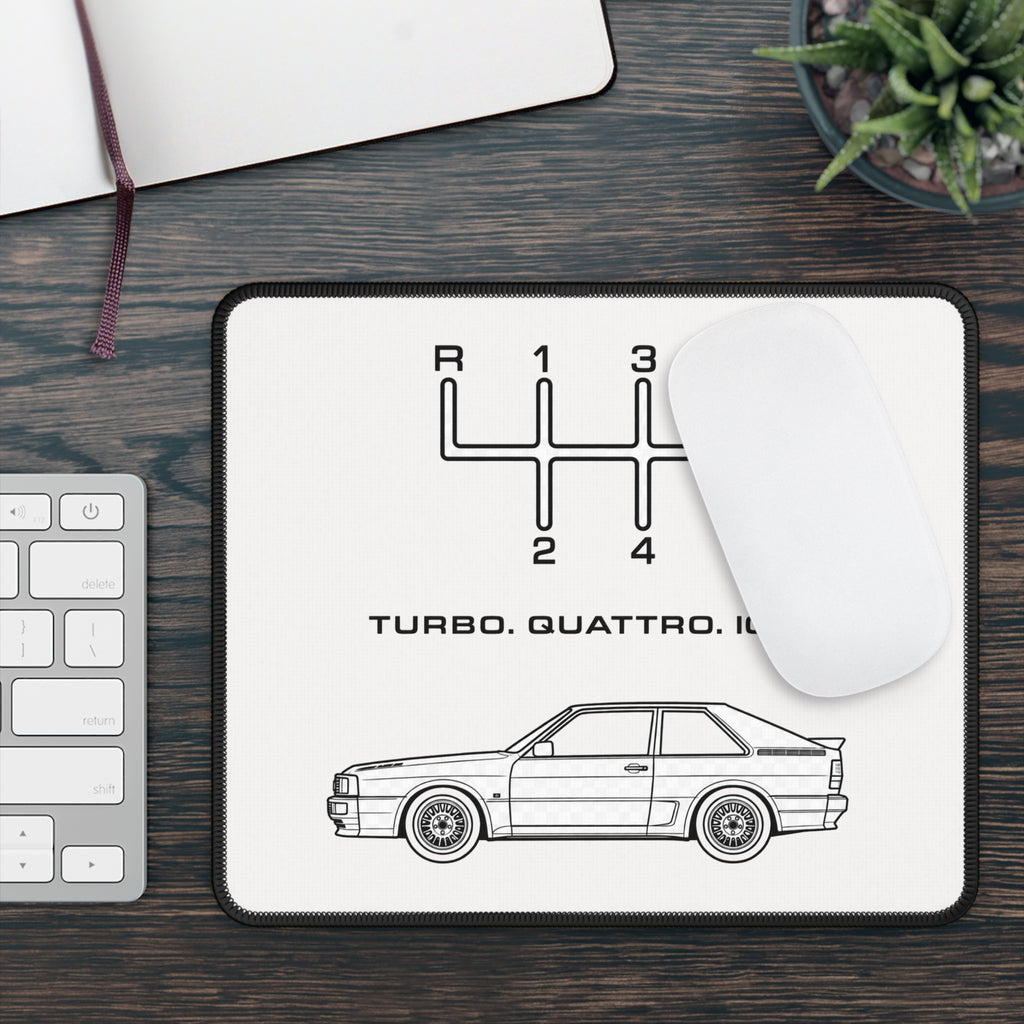 Classic rally car mouse pad on a dark wood workspace beside a keyboard and white computer mouse
