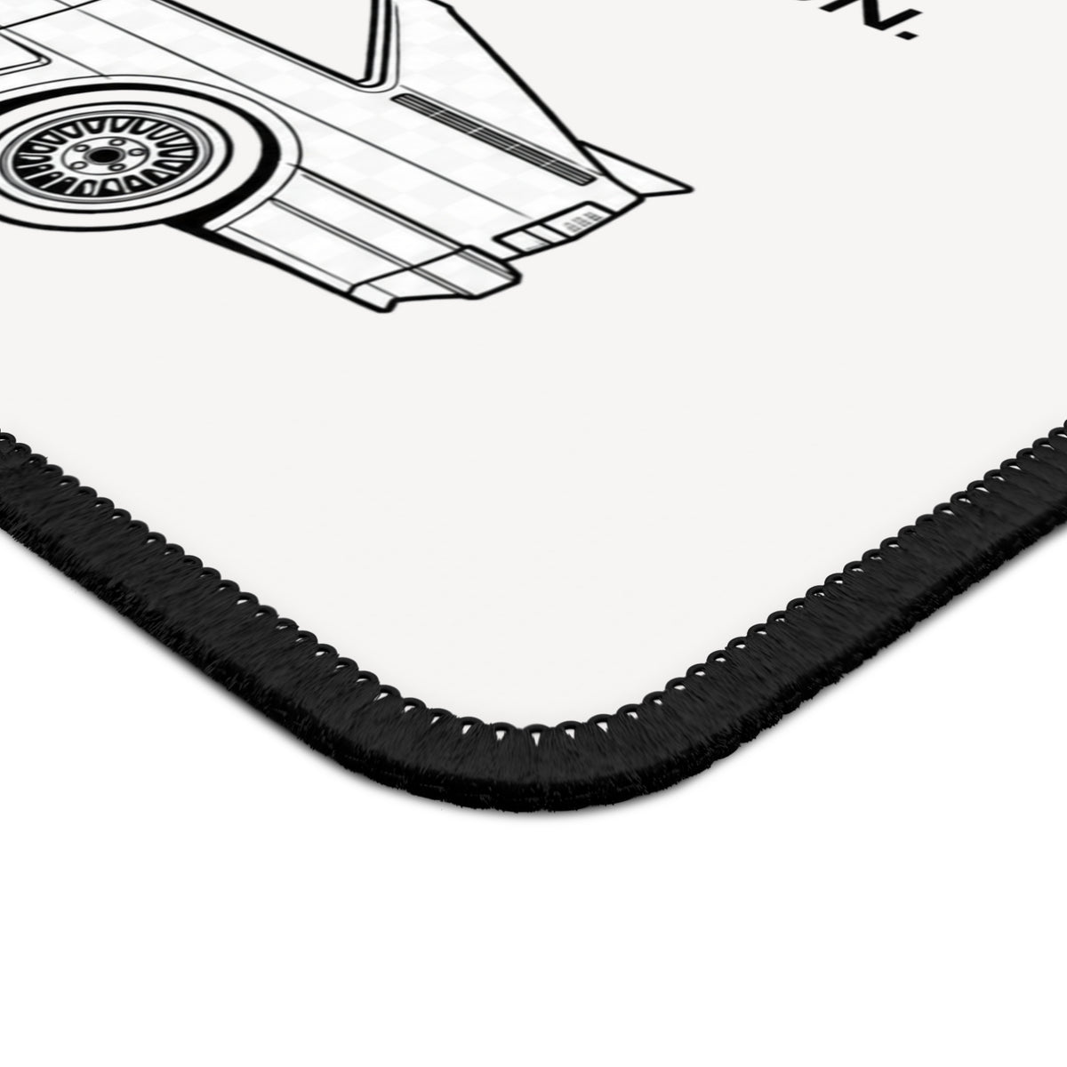 Close-up of mouse pad corner showing black stitched edging and detailed monochrome rally car illustration