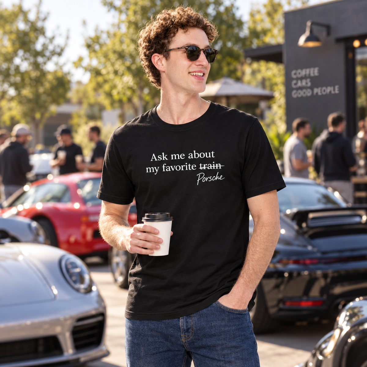 Model wearing black Porsche humor T-shirt at an outdoor cars and coffee event
