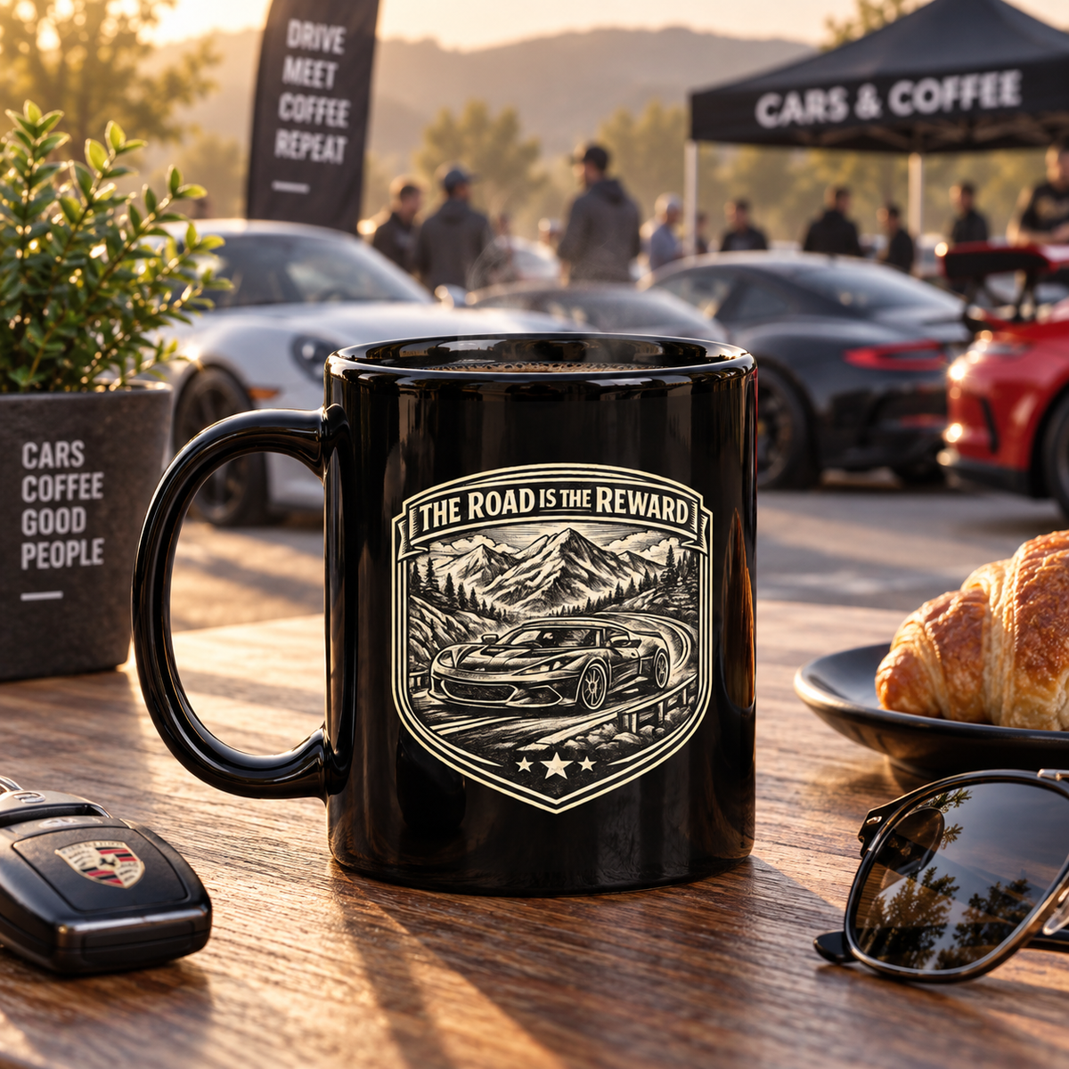 Black sports car coffee mug at a cars-and-coffee gathering with performance cars in the background