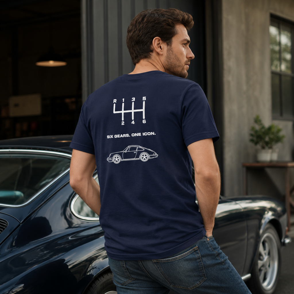 Navy Porsche 911 six-speed shift pattern T-shirt worn beside a classic sports car