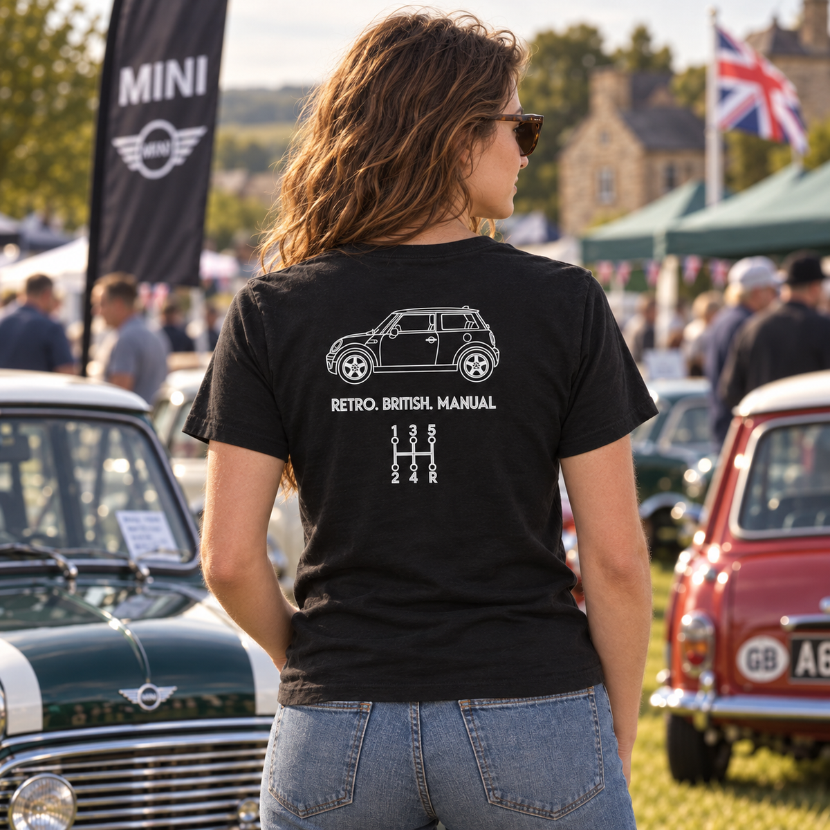 Woman wearing black Mini Cooper manual T-shirt with Retro British Manual back graphic at a classic car show