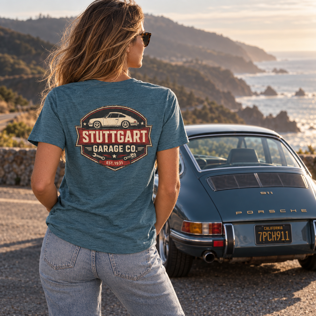 Woman wearing Heather Deep Teal Stuttgart Garage Co. T-shirt showing the back print beside a classic Porsche 911
