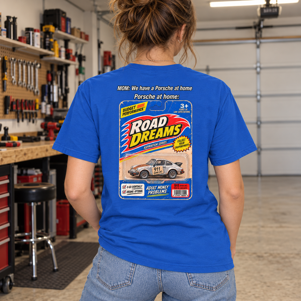 Woman wearing royal blue Porsche at Home T-shirt in a home garage, with Road Dreams toy-car graphic on the back