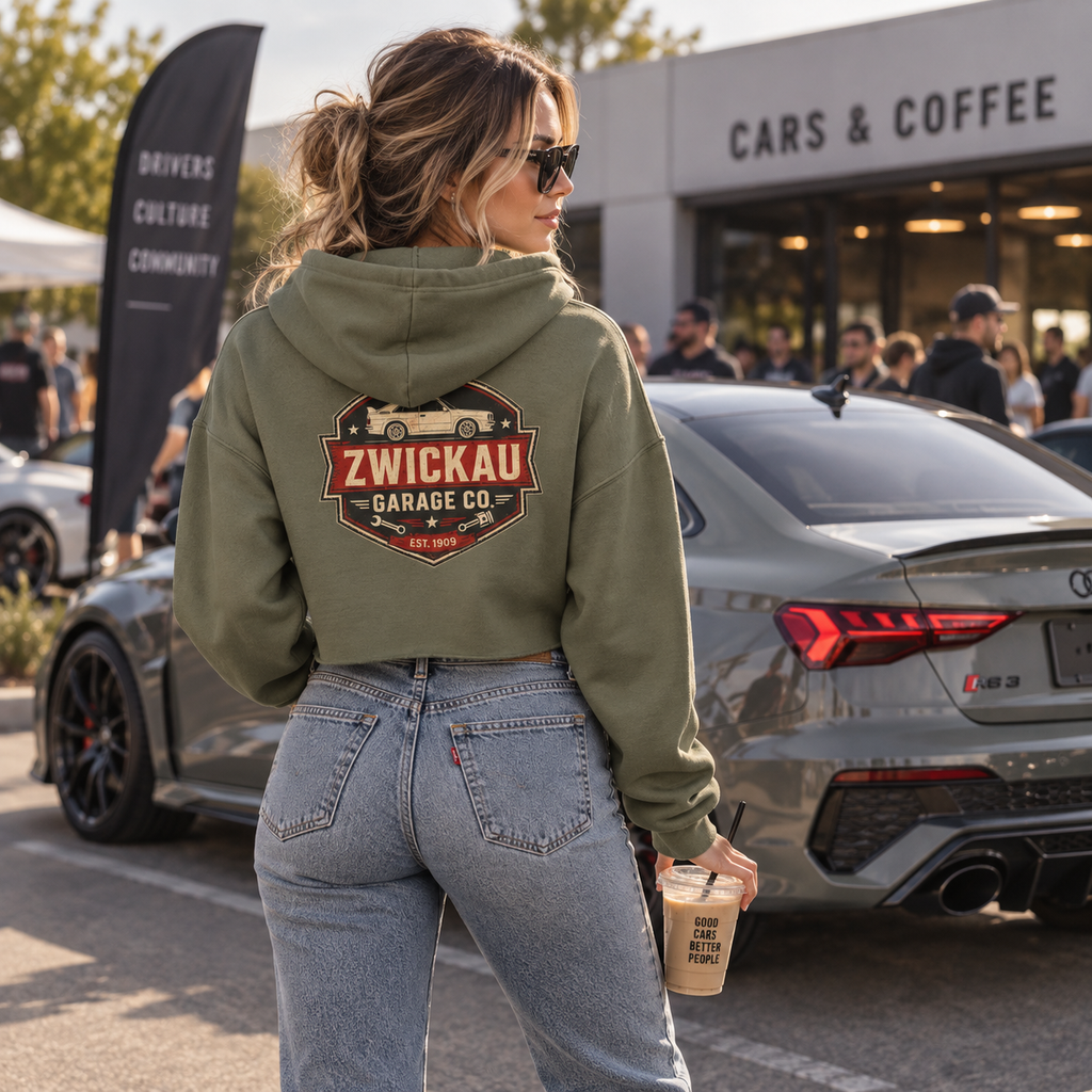 Woman wearing Military Green Zwickau Garage Co. cropped automotive hoodie with back graphic at cars and coffee.