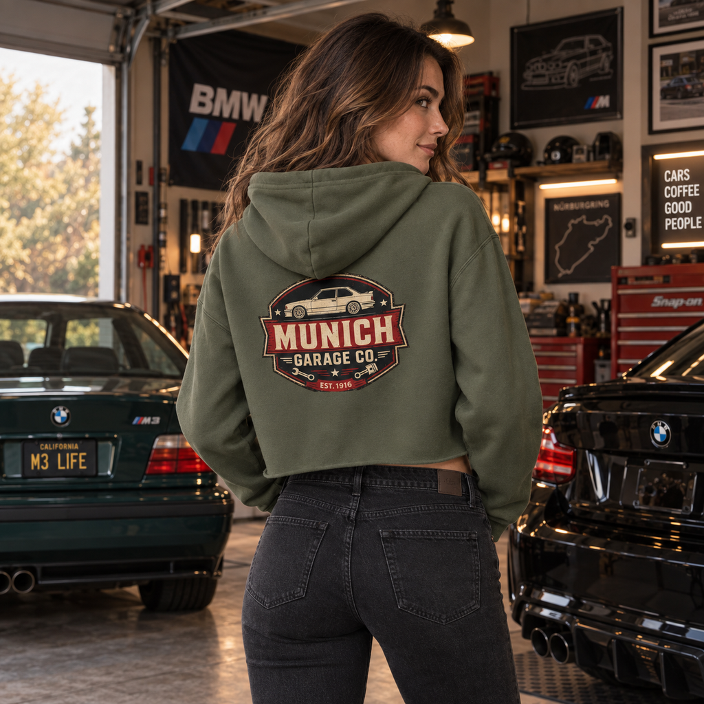 Back view of woman wearing Military Green Munich Garage Co. cropped hoodie with vintage German car graphic on the back.