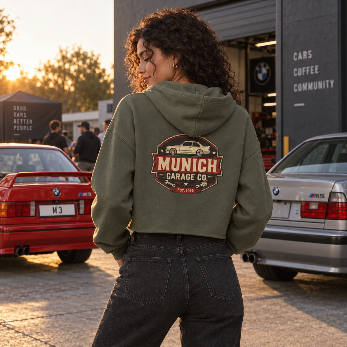 Women’s cropped automotive hoodie by Munich Garage Co. shown in a lifestyle photo with the back graphic visible.