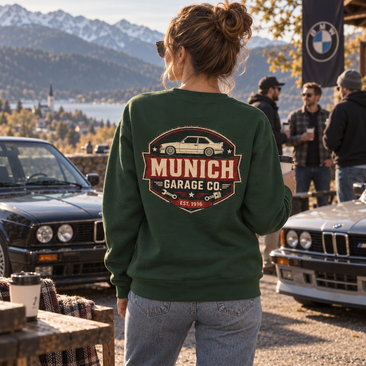 Woman wearing forest green Munich Garage Co. BMW sweatshirt at a mountain cars and coffee meet