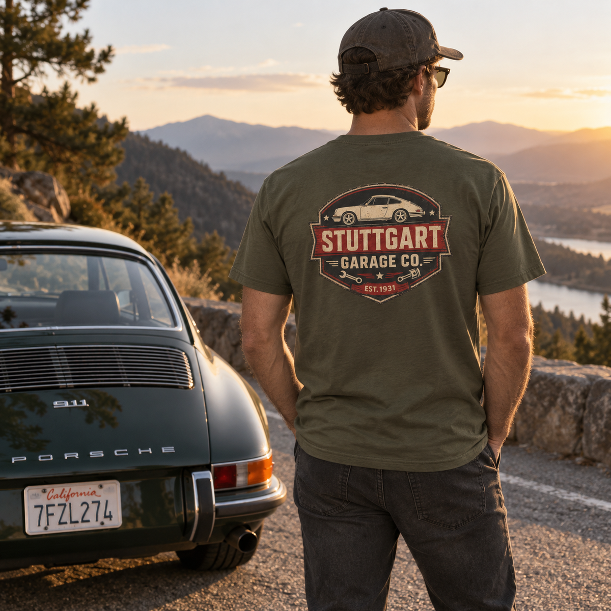 Man wearing Military Green Stuttgart Garage Co. T-shirt with back print beside a classic Porsche 911 at sunset