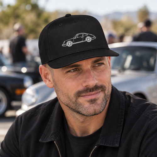 Black 5-panel hat with minimalist 911 silhouette graphic worn by car enthusiast