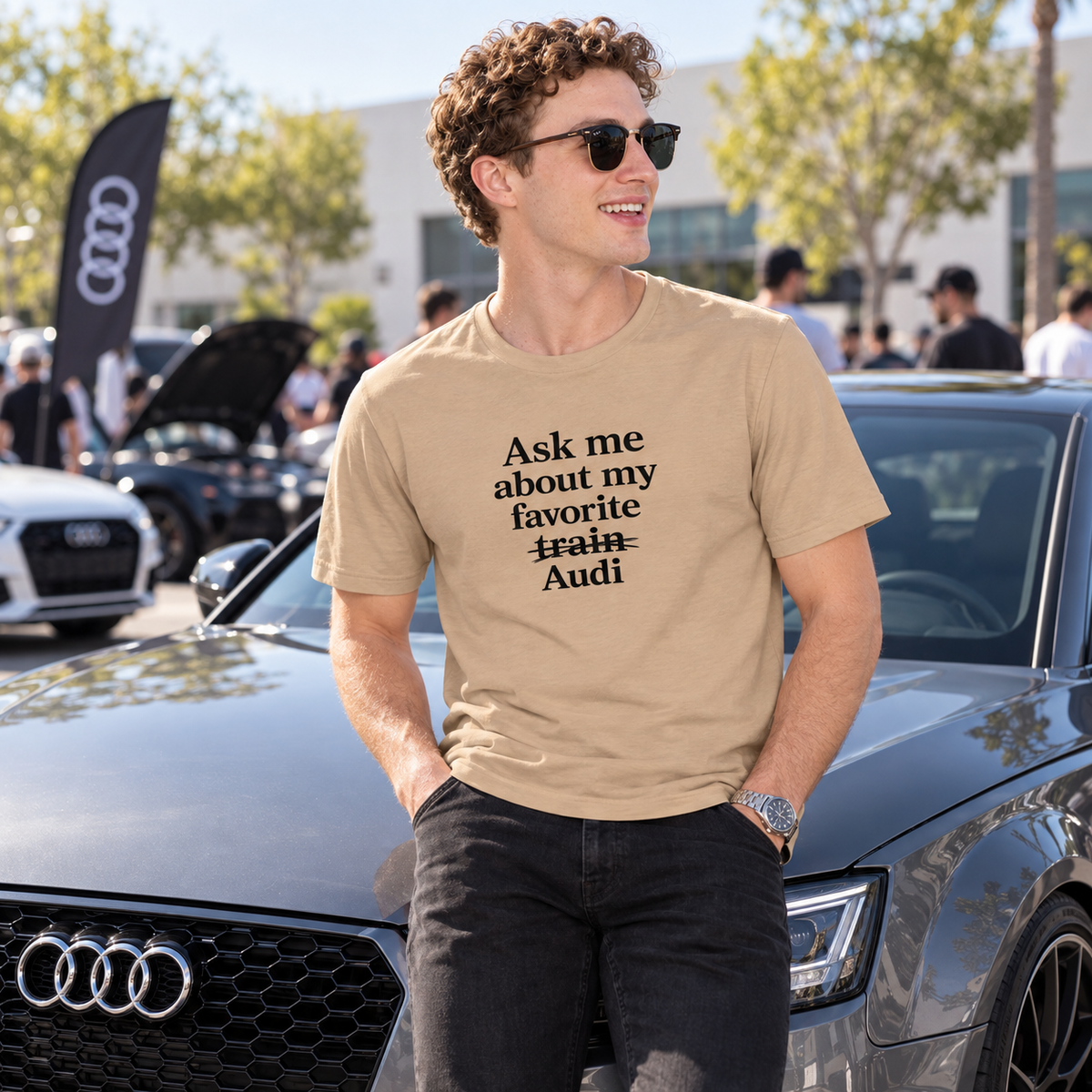 Man wearing tan Audi enthusiast T-shirt at a cars-and-coffee gathering