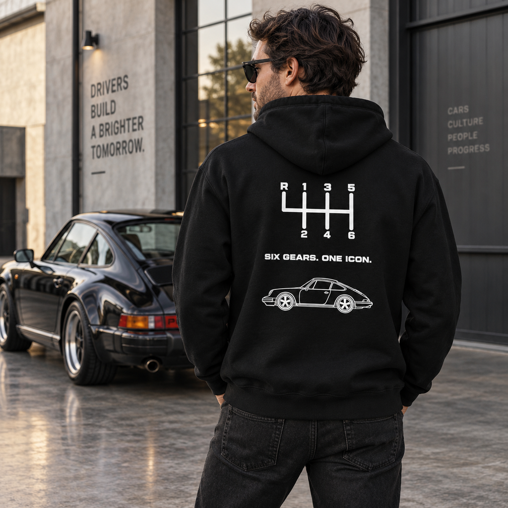 Man wearing black Six Gears One Icon hoodie outdoors, showing the white manual transmission back graphic