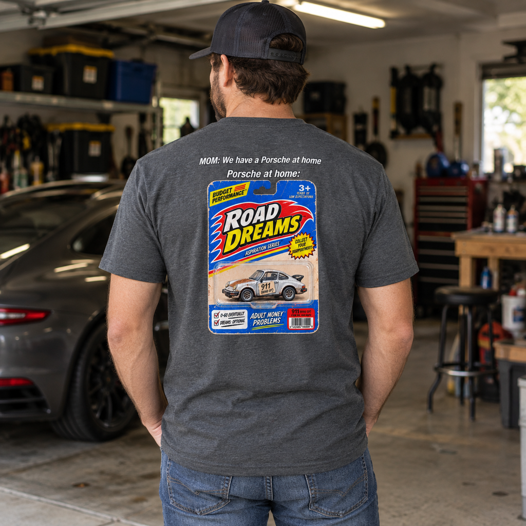 Man wearing dark heather Porsche at Home T-shirt in a garage, showing the Road Dreams parody back print
