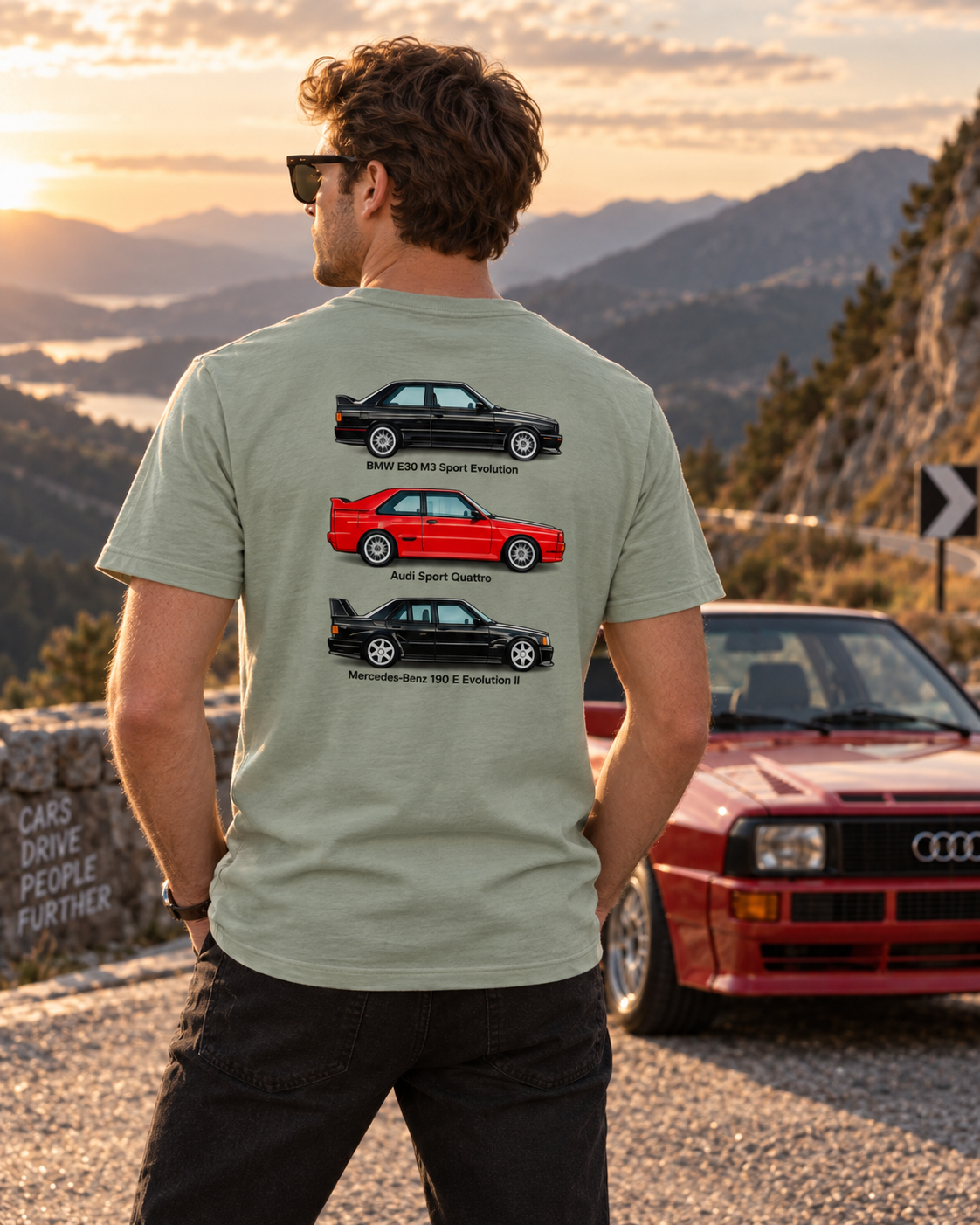 Male model wearing sage German Motorsport Legends T-shirt on a mountain pass, showing back print