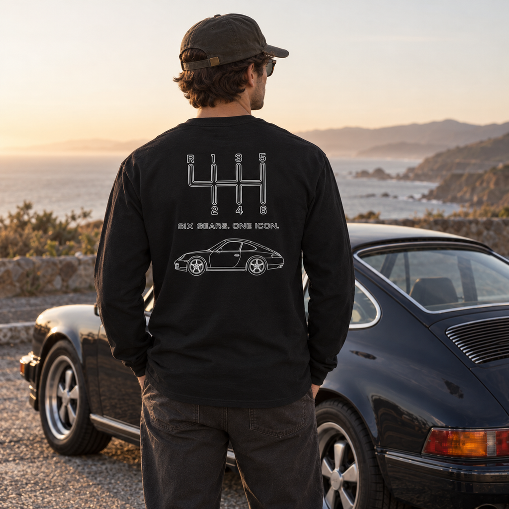 Black manual transmission long sleeve shirt with Six Gears One Icon back graphic at a coastal overlook