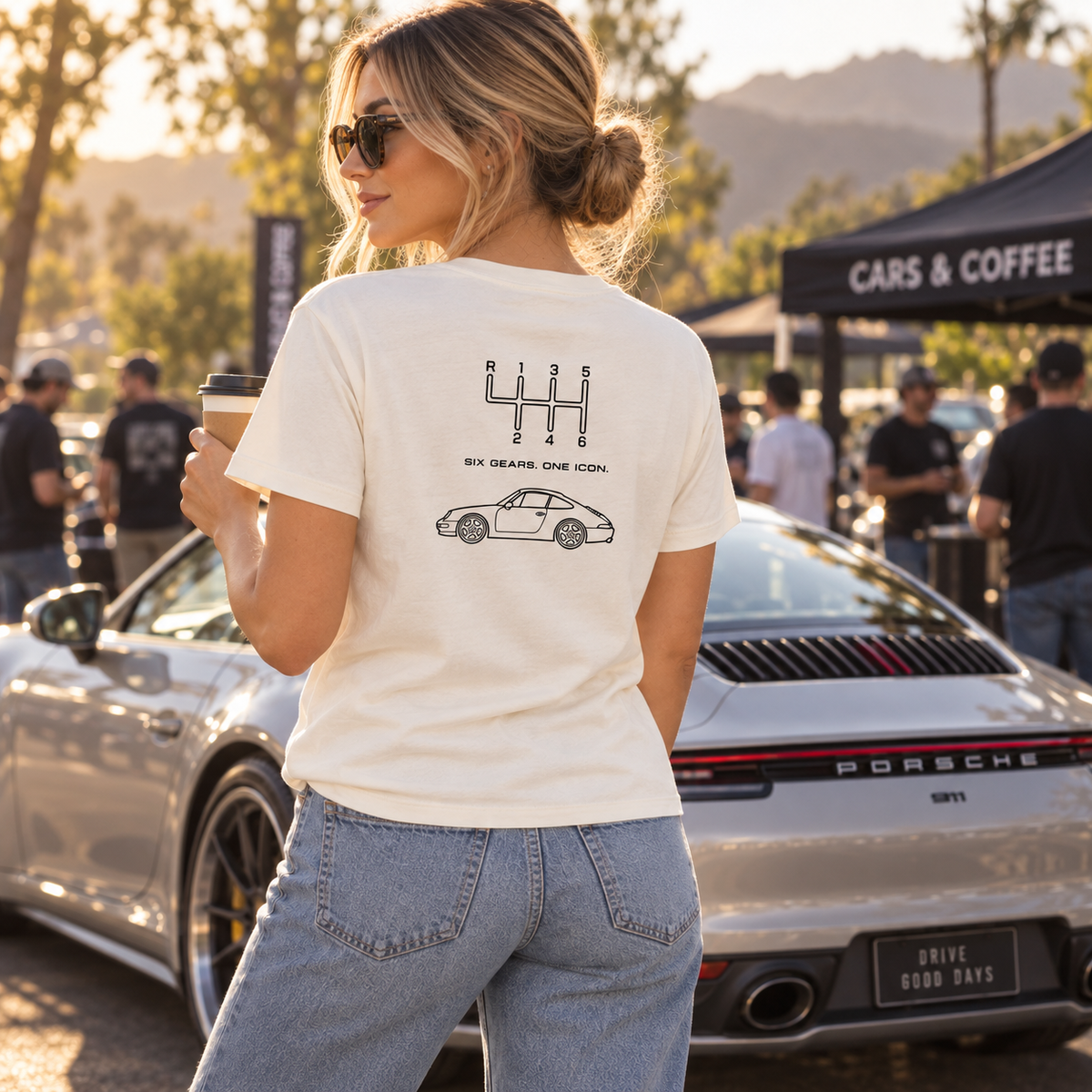 Woman wearing natural-colored Six Gears One Icon 911 T-shirt at cars and coffee