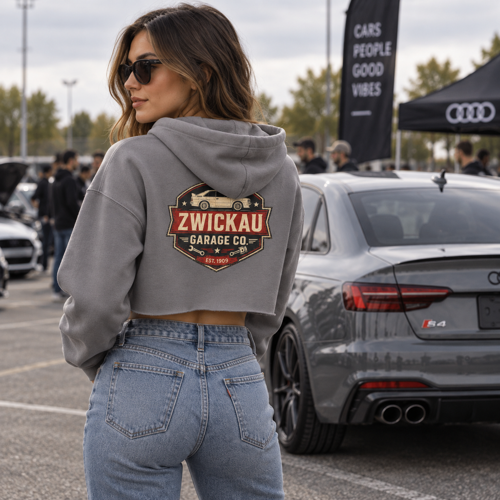 Woman wearing Storm gray Zwickau Garage Co. cropped hoodie with back graphic at an automotive event.