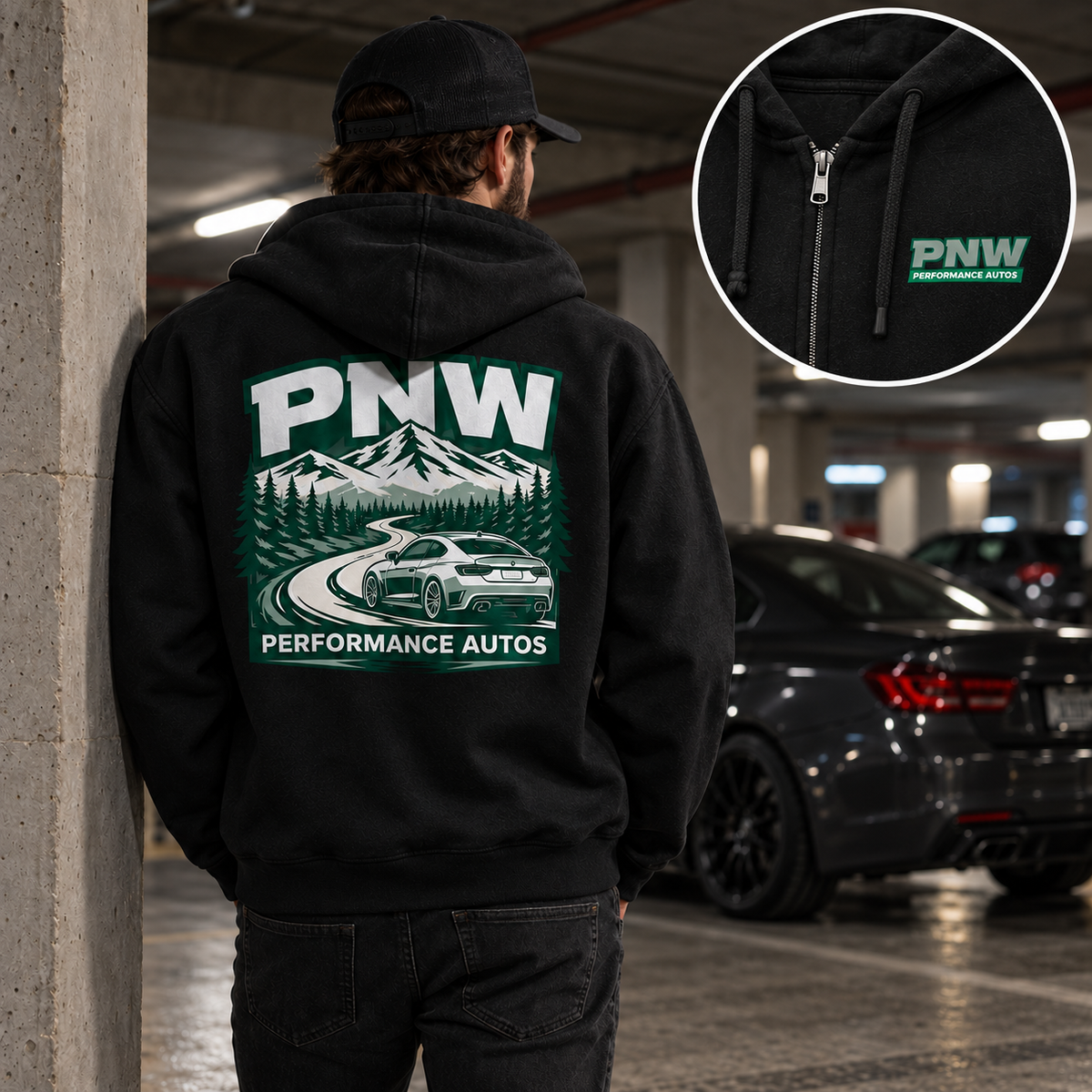 Rear view of a man wearing a black PNW Performance Autos full-zip hoodie in a dim concrete parking garage, showing the mountain-road sports car back print; enlarged inset highlights the front chest logo and zipper.