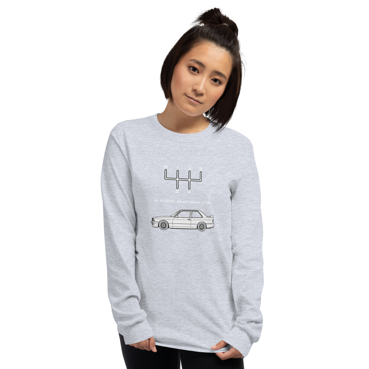 Woman wearing Sport Grey E30 M3 long sleeve T-shirt with dark manual transmission and classic car artwork.