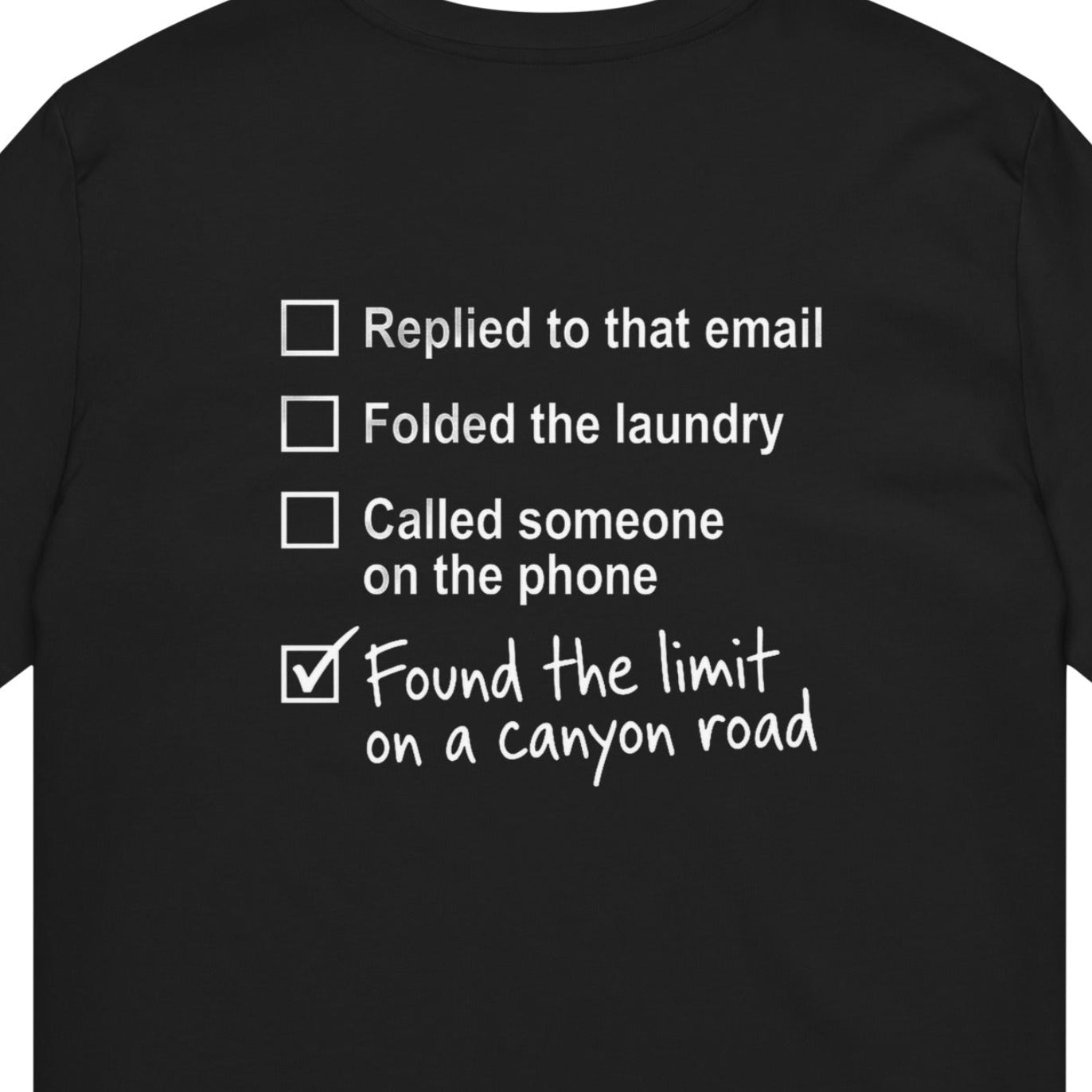 Close-up of black canyon road T-shirt back graphic with checklist and Found the limit on a canyon road message