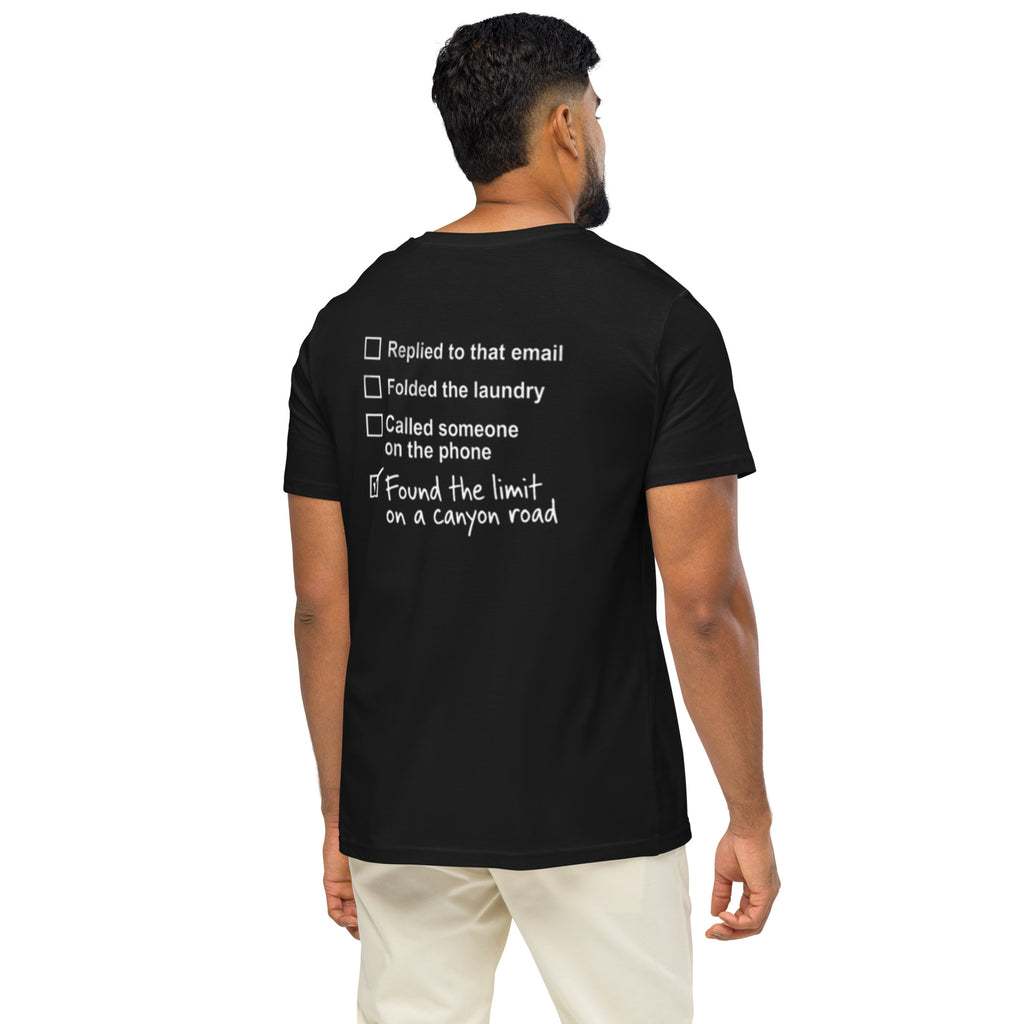 Model wearing black canyon road driving T-shirt showing funny checklist graphic on the back