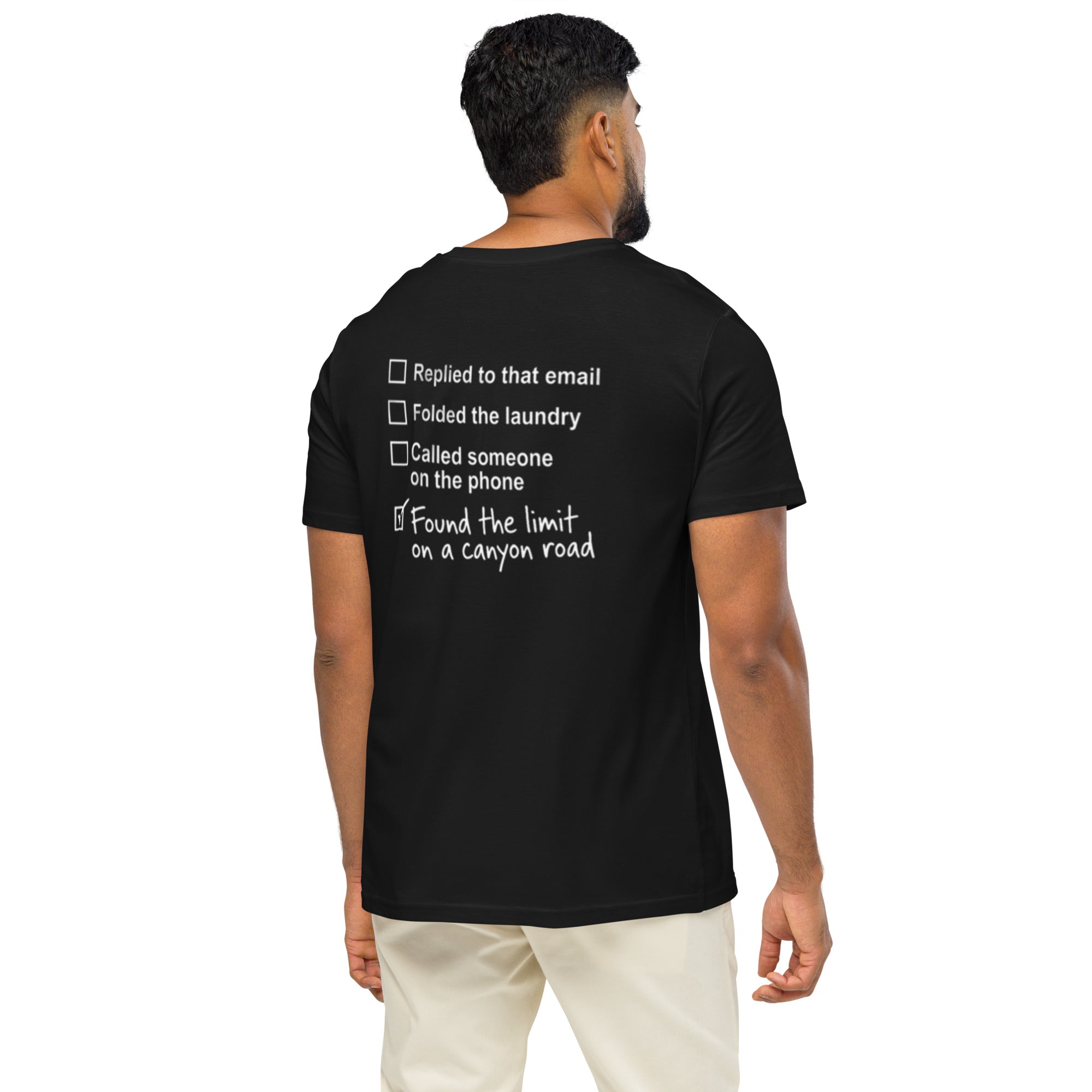 Model wearing black canyon road driving T-shirt showing funny checklist graphic on the back
