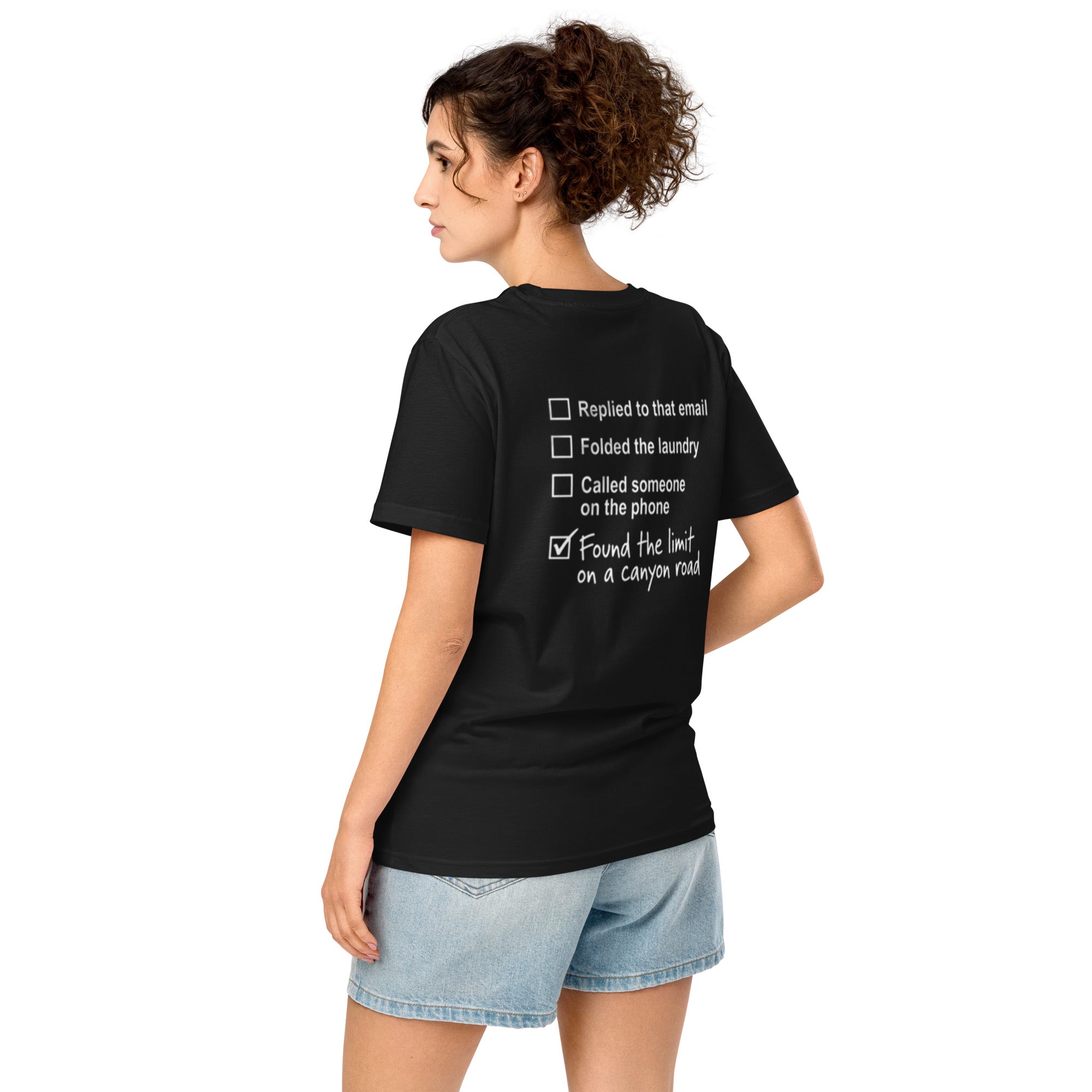 Three-quarter view of model wearing black canyon road driving T-shirt with checklist back graphic